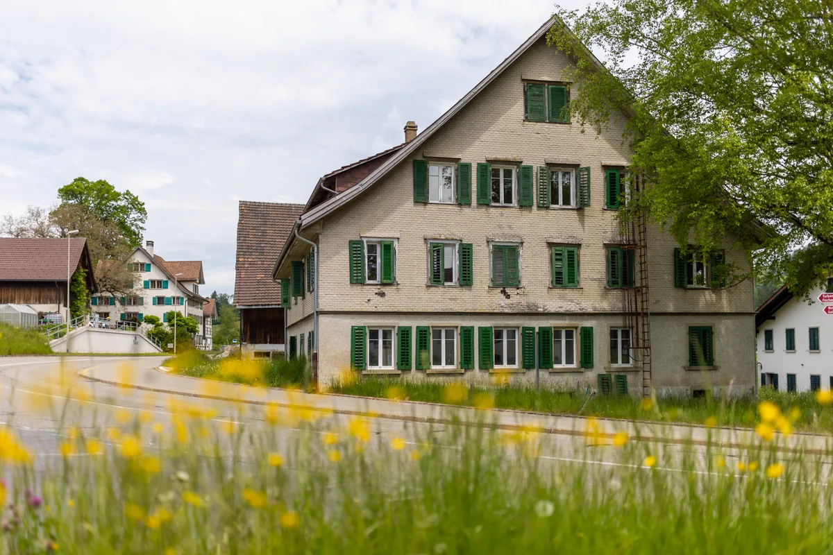 So sah das 250-jährige Bauernhaus vor Beginn der Sanierung aus. Einst wurden hier Asylsuchende untergebracht. Ein altes Bauernhaus mit grünen Fensterläden.
